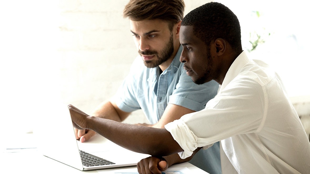 Dos compañeros de trabajo mirando la pantalla de un portátil
