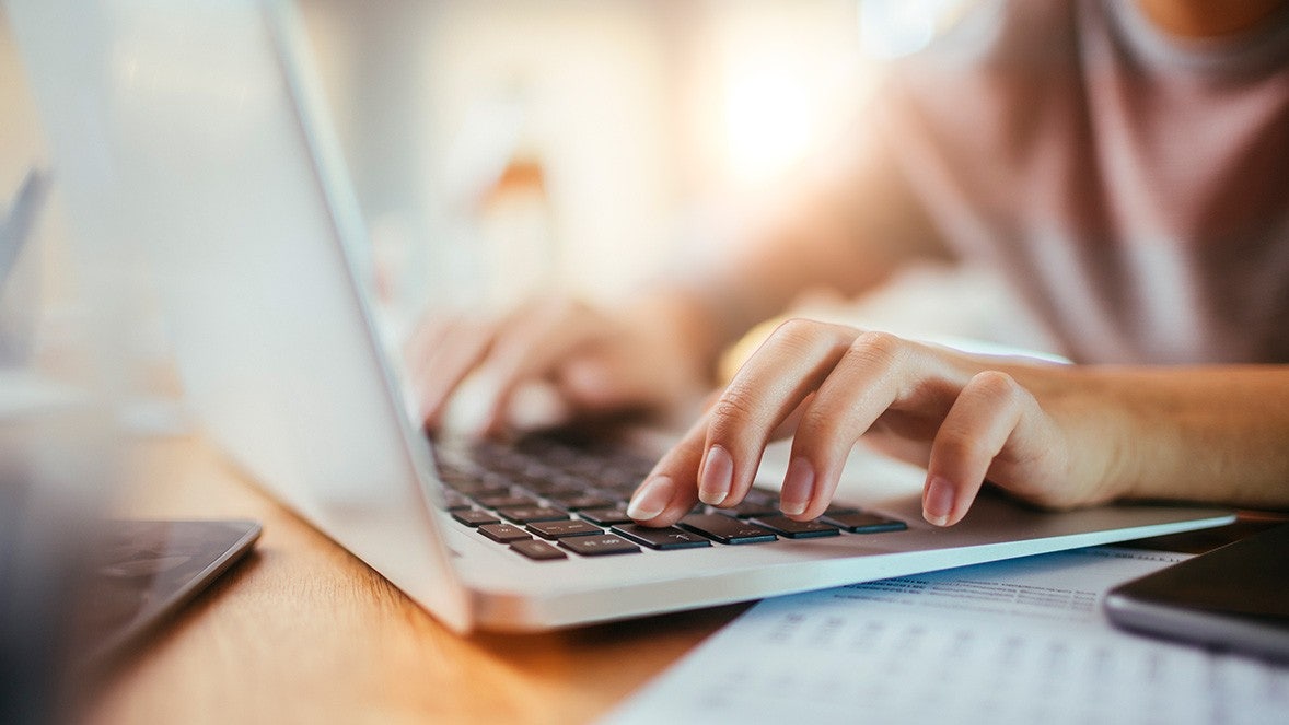 Primer plano de manos trabajando en un pórtatil