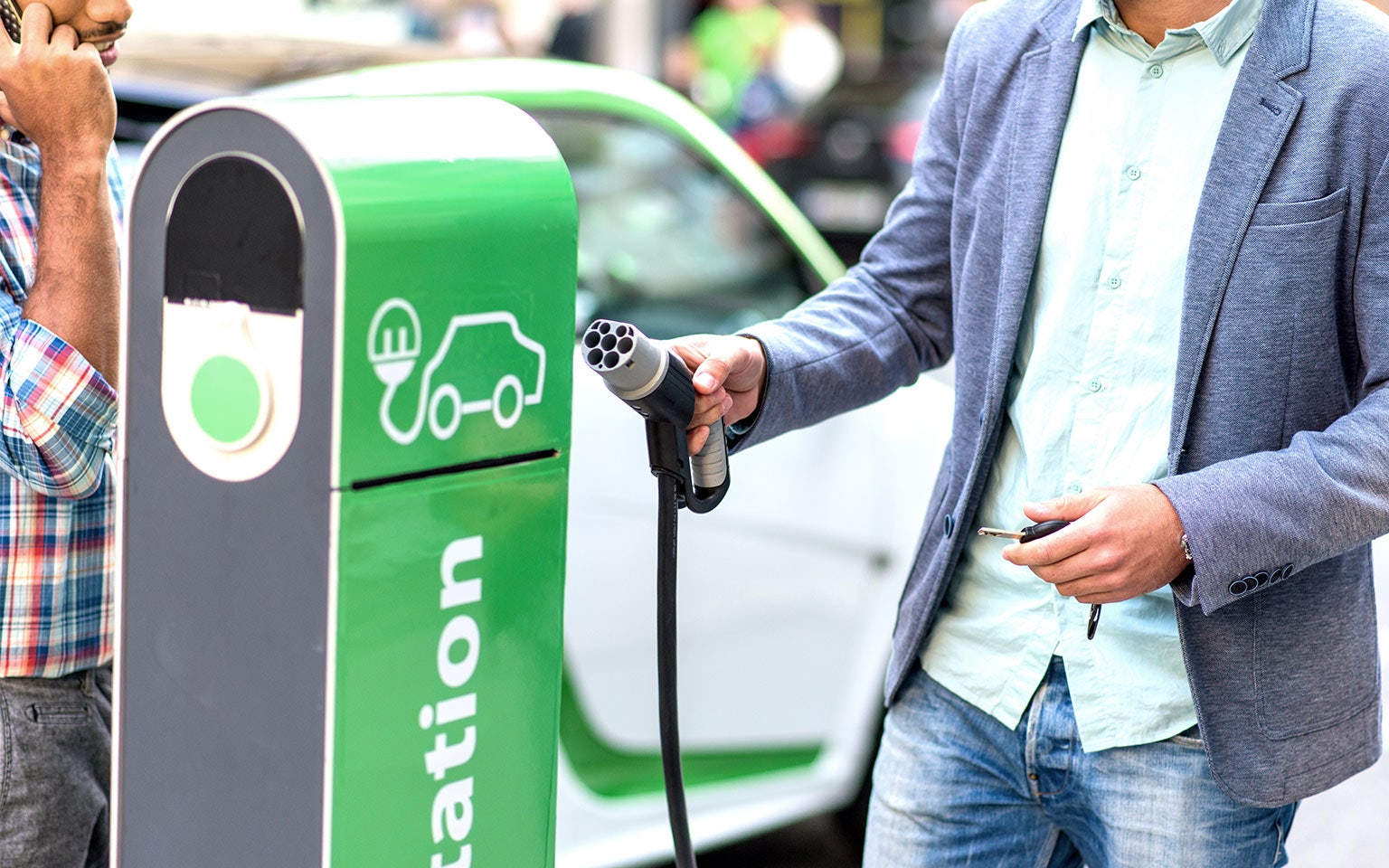 Hombre cargando un coche eléctrico