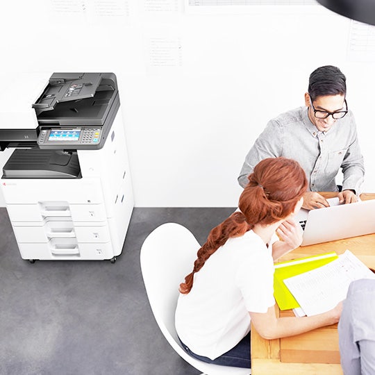 Colegas teniendo una reunión junto a MFP Kyocera