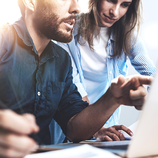hombre apuntando un la pantalla de un portatil