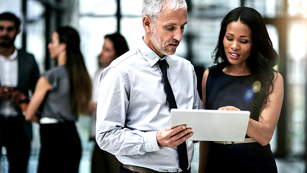 dos compañeros de trabajo mirando la pantalla de un portatil