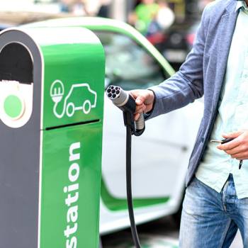 El innovador cargador de coches eléctricos. Hombre cargando un coche eléctrico