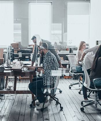 empleados trabajando un una oficina acristalada